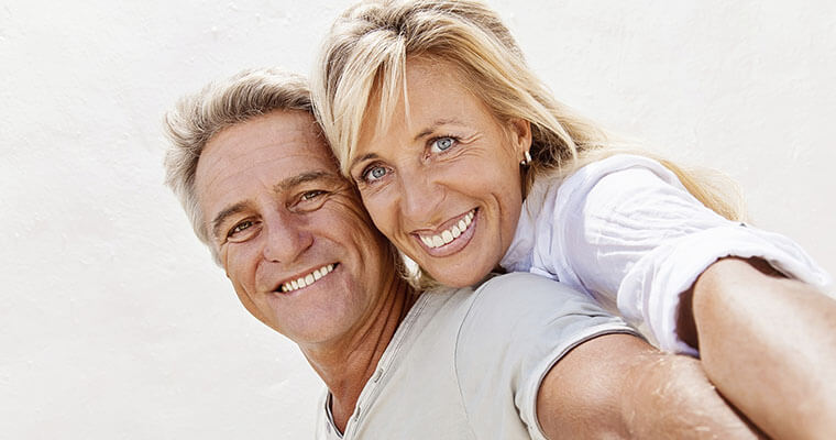 Mature male and female embrace and smile